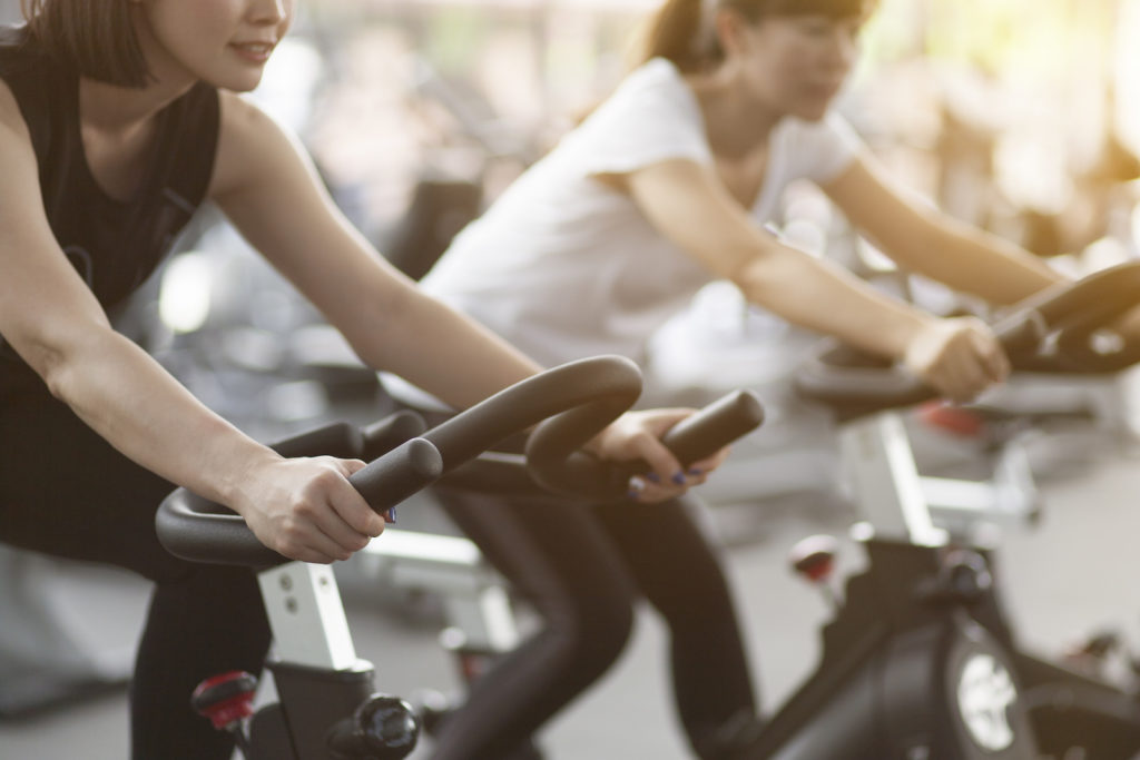 Close-up footage of a women working out in gym on the exercise bike, young woman cycling in the gym. female exercising in fitness gym for good health.